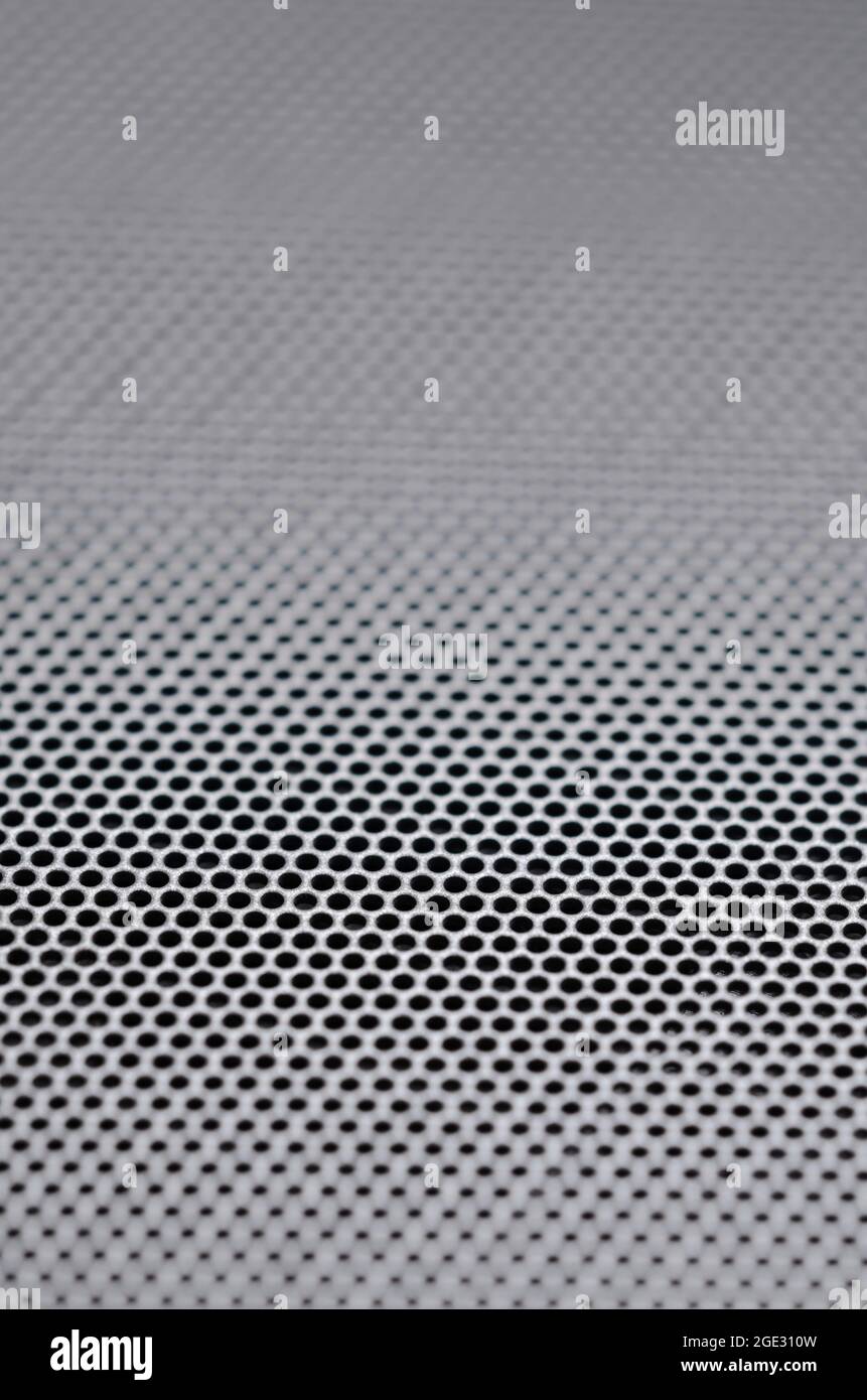 Close-up of metallic mesh grid with perforation or dots pattern, metal textured surface with shallow depth of field as abstract technology background Stock Photo