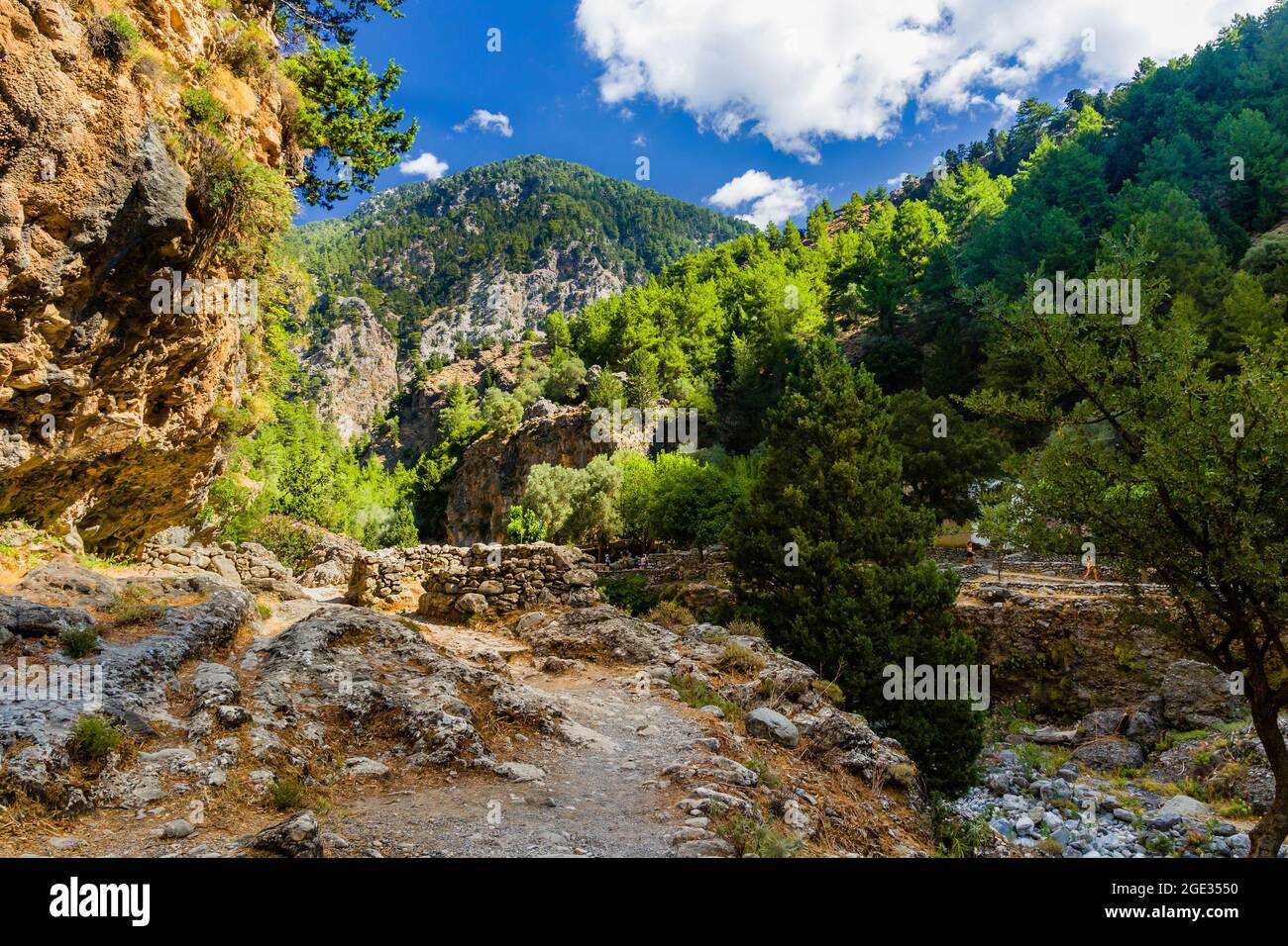 Dry riverbed and towering cliffs in a huge natural gorge (Samaria Gorge ...
