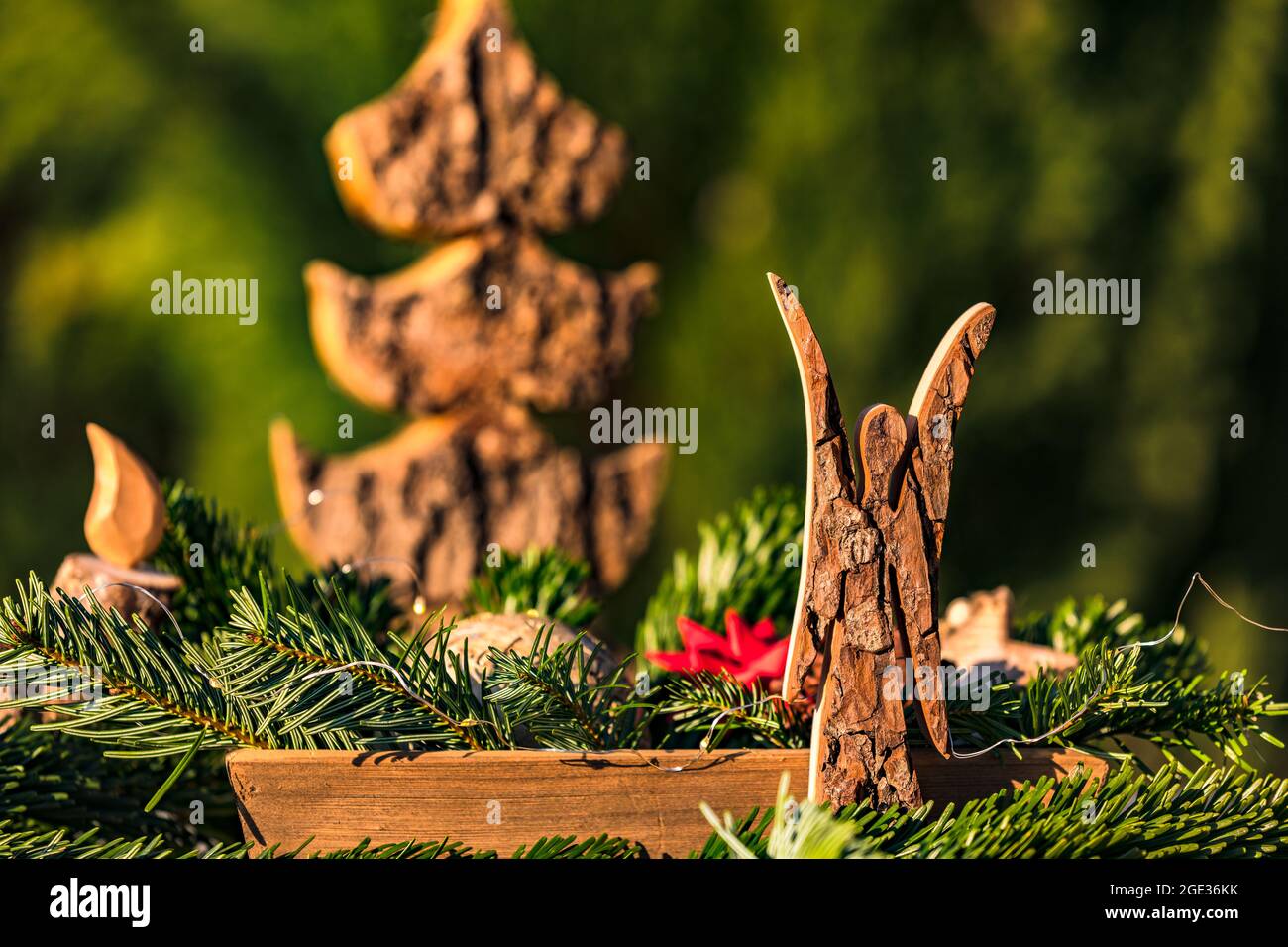 A flower arrangement with fir branches and a wooden angel decorated for Christmas Stock Photo