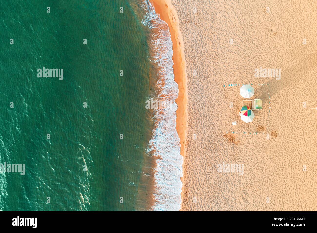 Aerial top view on the beach. Umbrellas, sand and sea waves Stock Photo