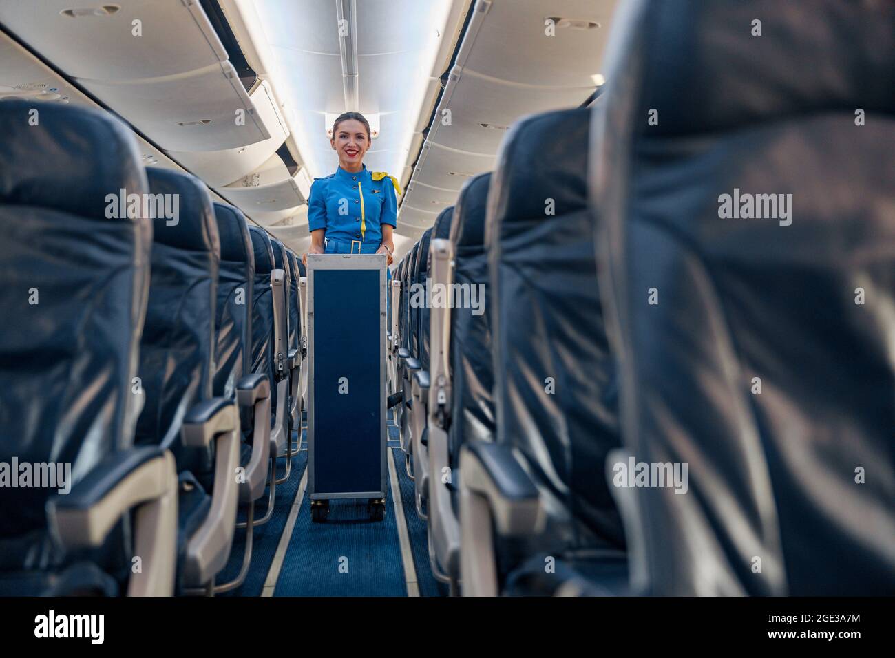 Female cabin attendant leading trolley cart through empty plane aisle Stock  Photo - Alamy