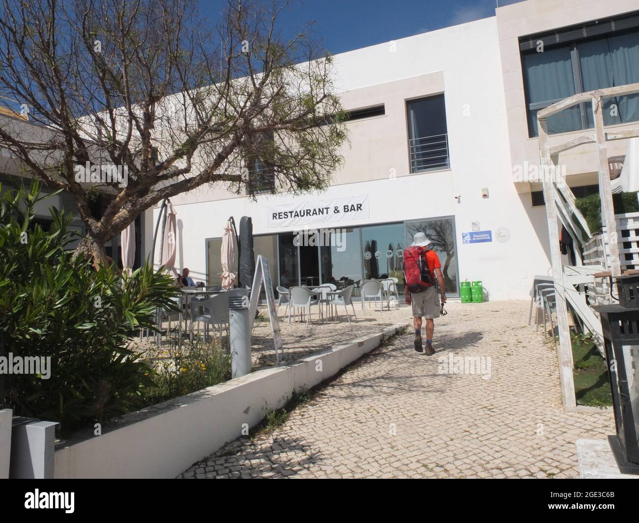 Walker arriving at a youth hostel, Arrifana, Algarve, southern Portugal Stock Photo