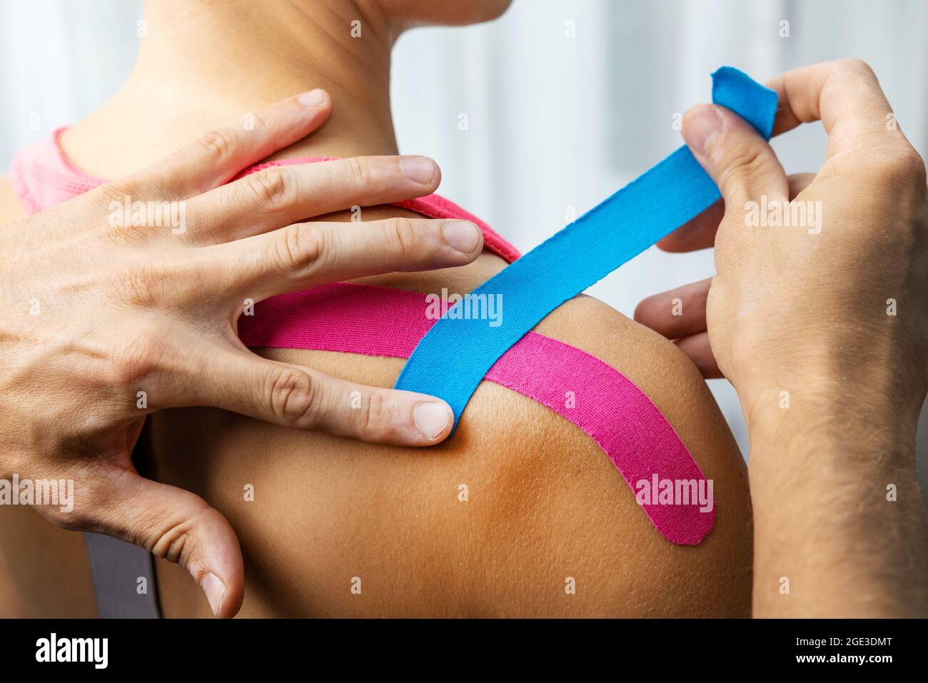 kinesiotaping - physiotherapist taping injured patient shoulder with kinesio tape after muscle injury Stock Photo