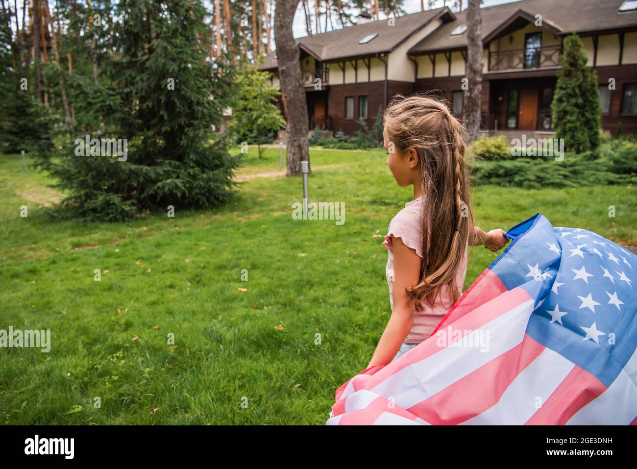 Girl holding american flag on lawn outdoors Stock Photo - Alamy