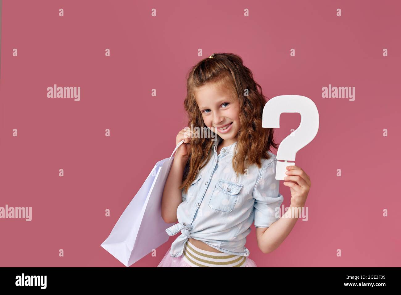 child girl holds many shopping bags and question mark Stock Photo Alamy
