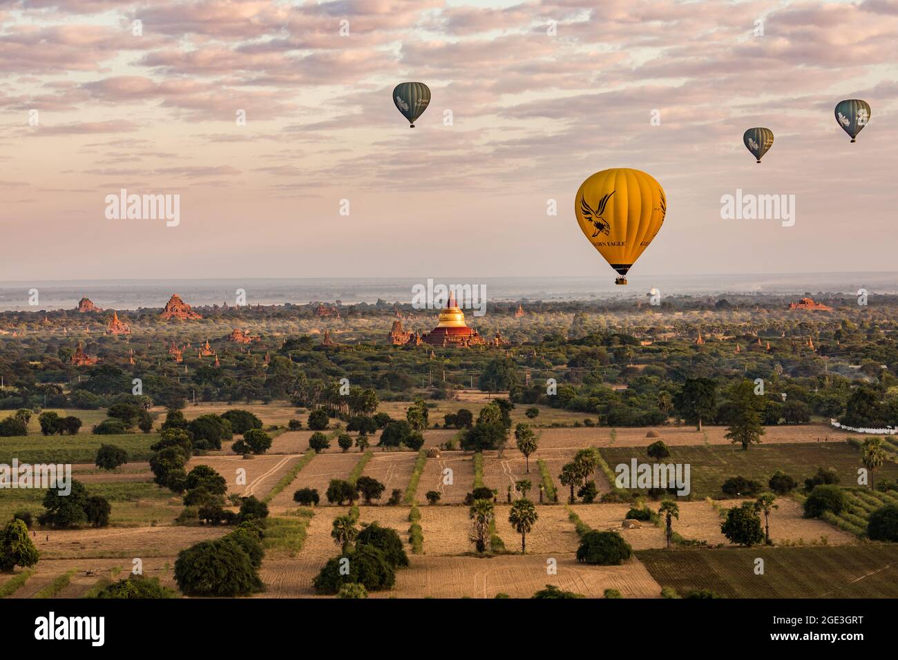 Panorama at sunrise with balloons in front of the distinctive Dhammayazika Pagoda in Bagan in Myanmar Stock Photo