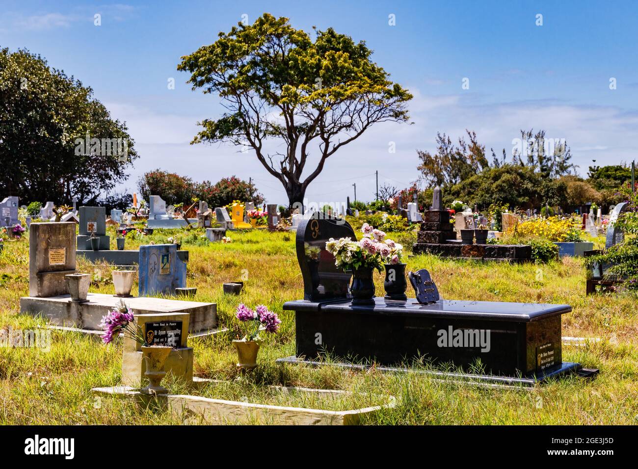 A colorful and sun-drenched multi-religious cemetery on the island of Mauritius in the Indian Ocean Stock Photo
