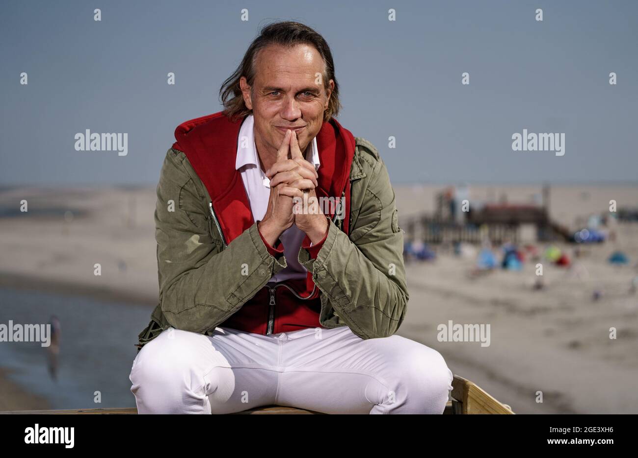 Sankt Peter Ording, Germany. 12th Aug, 2021. Actor Ralf Bauer sits on ...