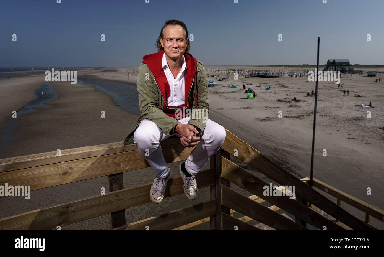 Sankt Peter Ording, Germany. 12th Aug, 2021. Actor Ralf Bauer sits on ...