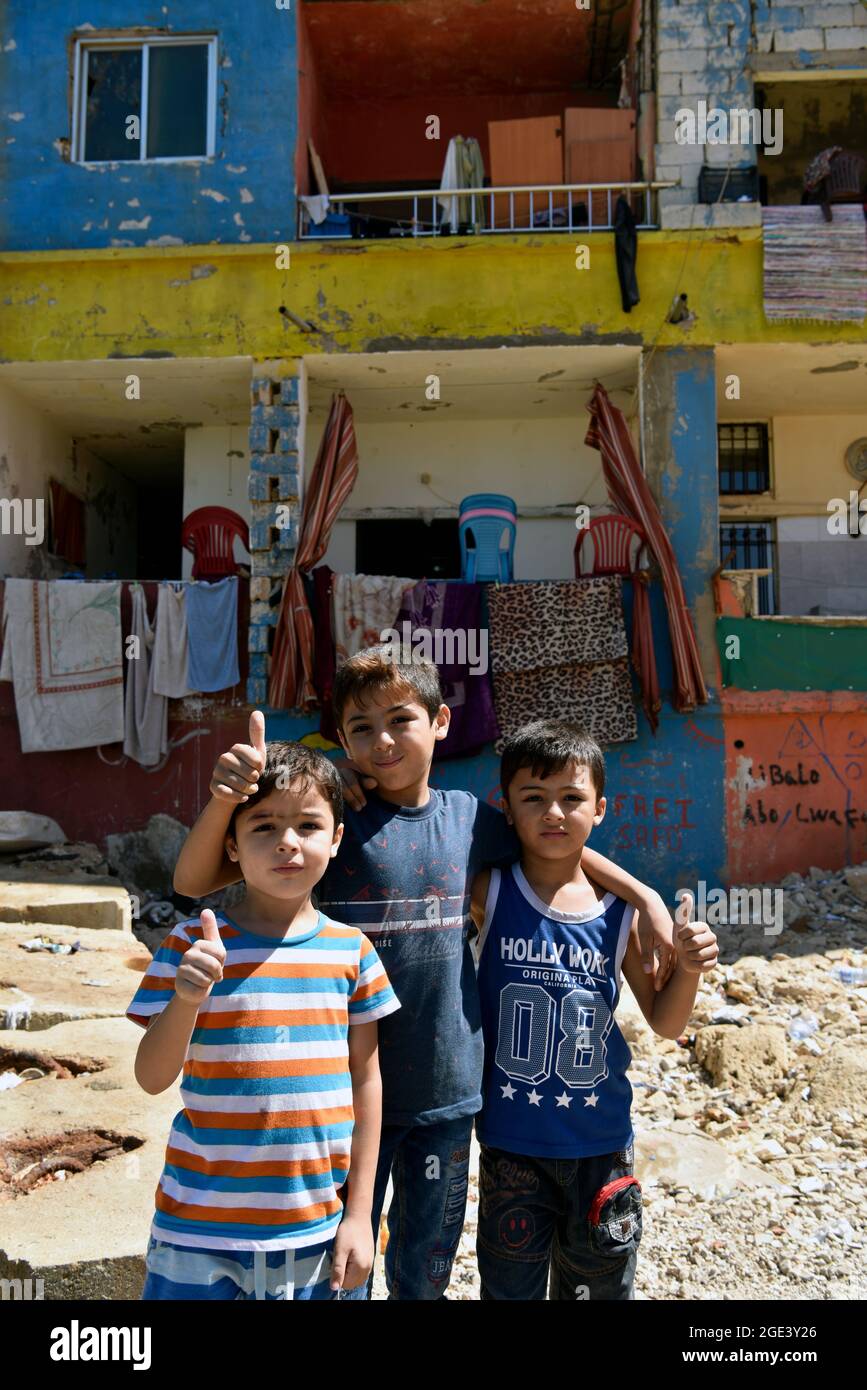 Youngsters posing for a photo in the poor neighbourhood of Ouzai, southern suburbs, Beirut, Lebanon. Stock Photo