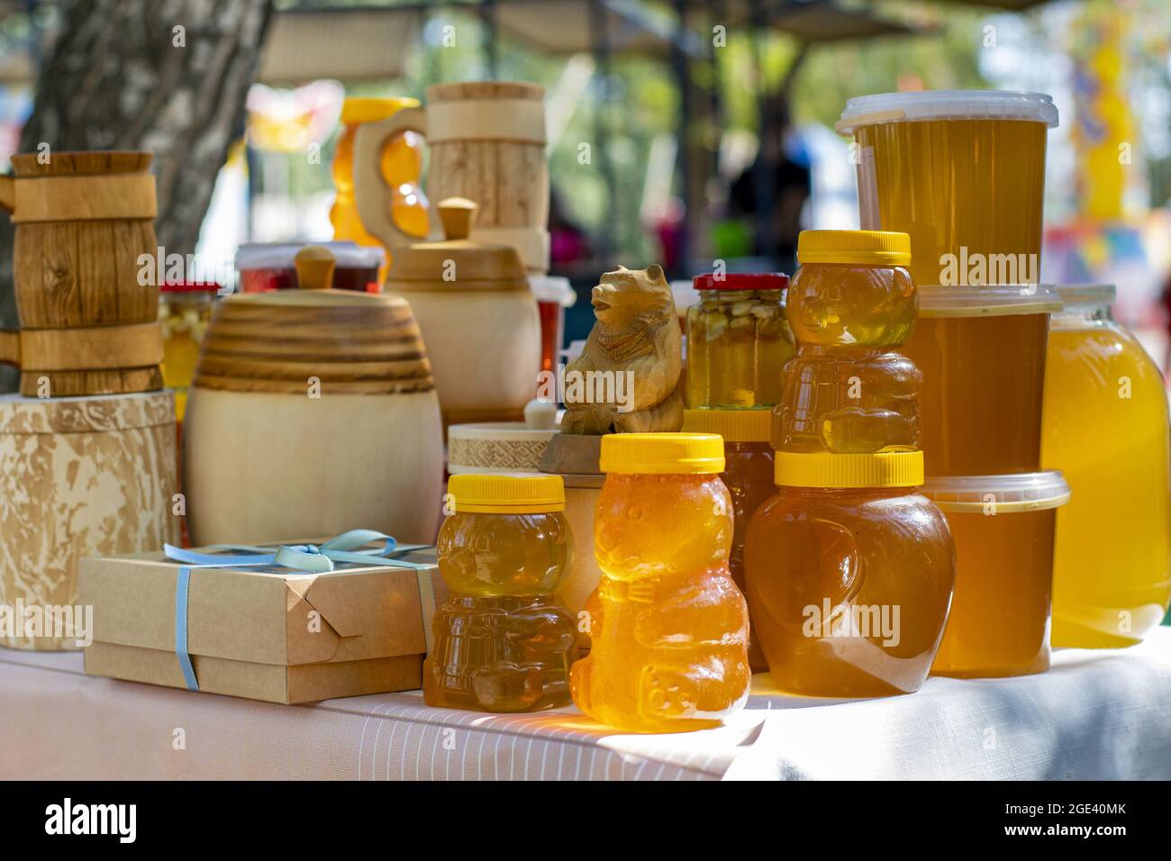 Bee honey is packaged in glass, plastic and wooden containers and is ready  for sale on the market Stock Photo - Alamy