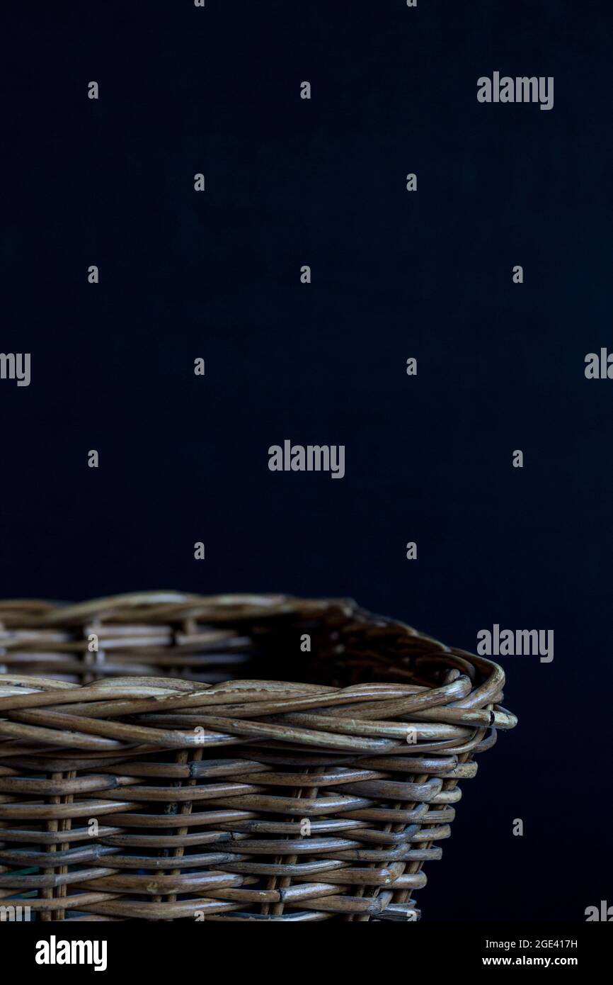 Empty wicker basket on a black background. Stock Photo