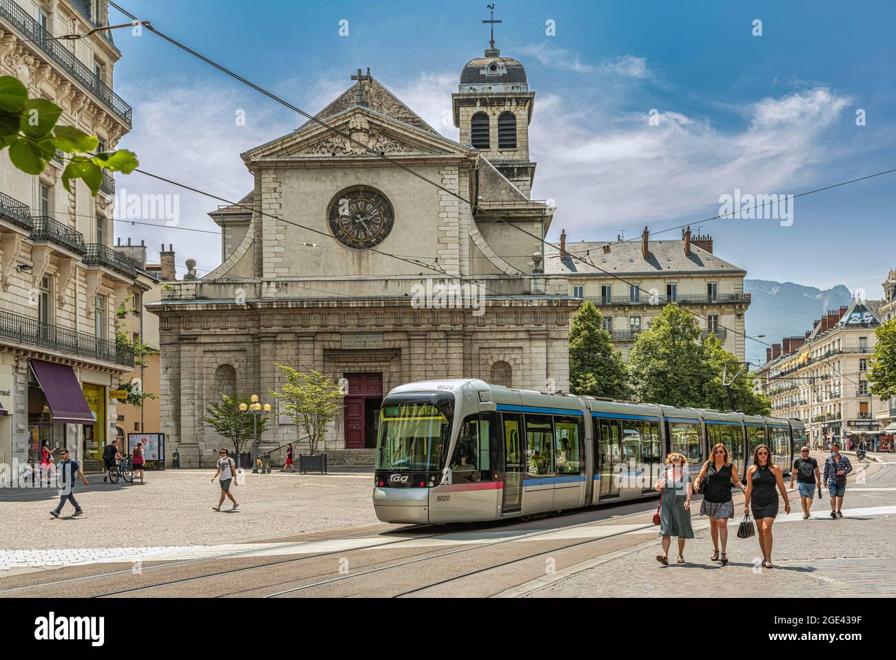 Tourists stroll past the Saint Louis church on Rue Félix Poulat in Grenoble on a sunny summer day. Grenoble, France Stock Photo