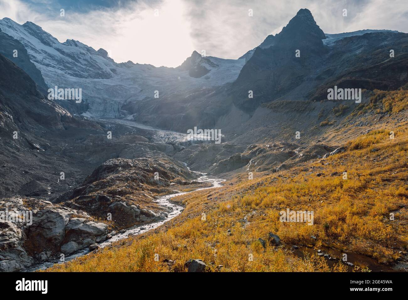 Mountains, glacier and autumnal grass. High mountain landscape with ...