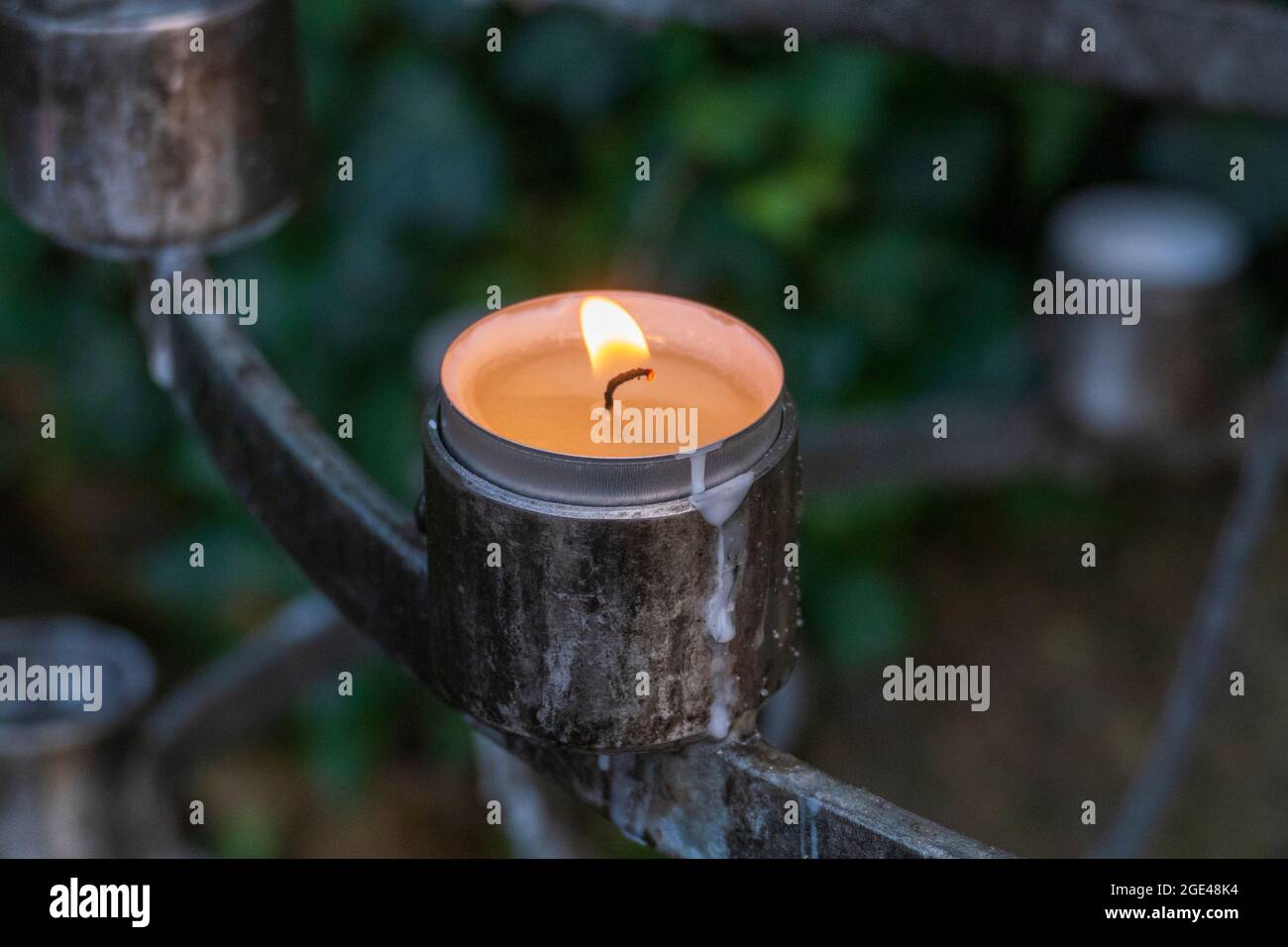Brennende Kerze, Teelicht in einer Kirche, Sinnbild für Fürbitten Stock Photo
