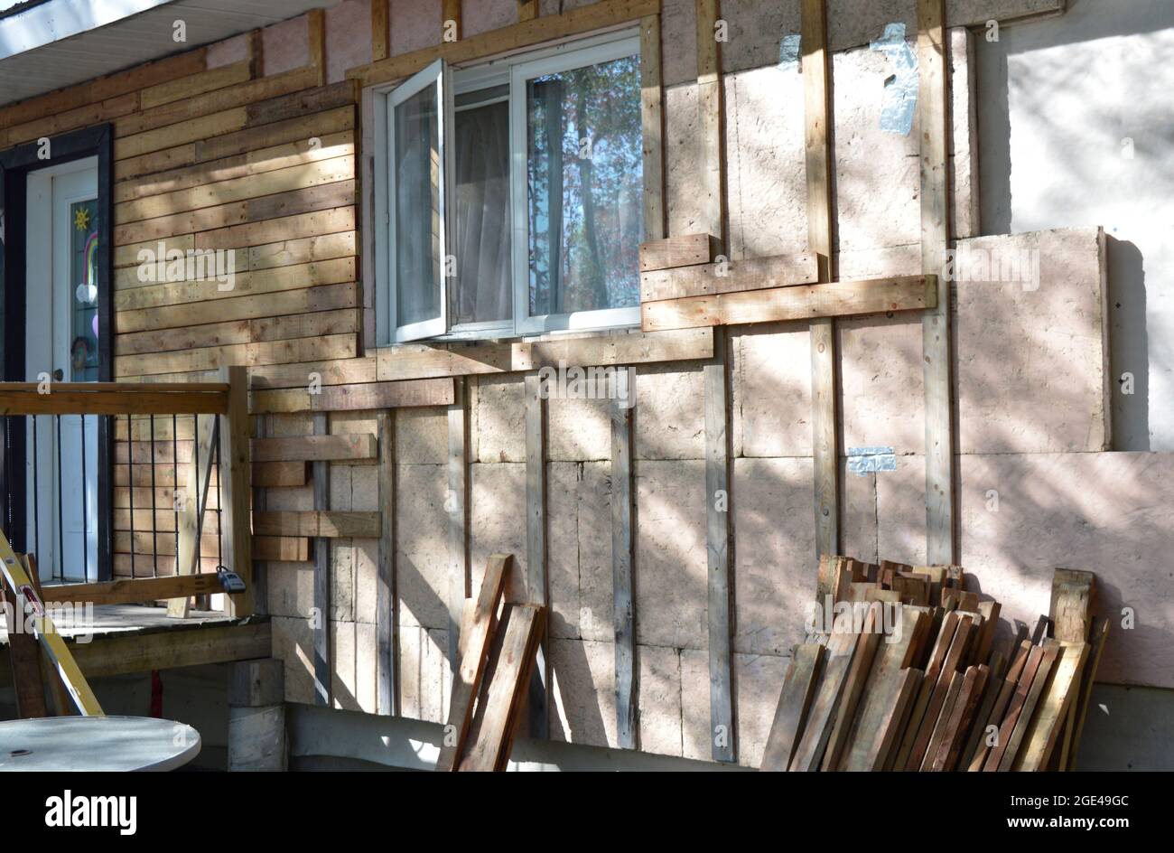 People changing their siding and adding insulation to a home Stock