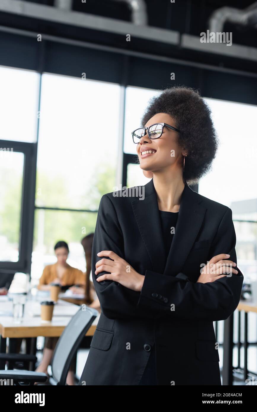 stylish african american businesswoman smiling while standing with ...