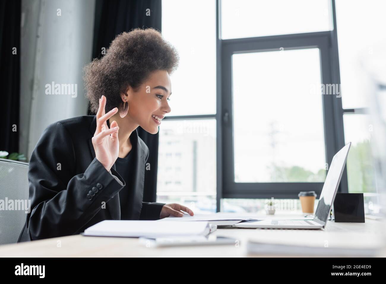 smiling african american businesswoman waving hand during video call in ...