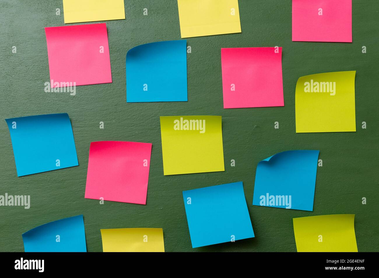 Many blank colorful memory stickers on a dark green background. The empty space on multi-colored office stickers. Busy day, business concept. Stock Photo