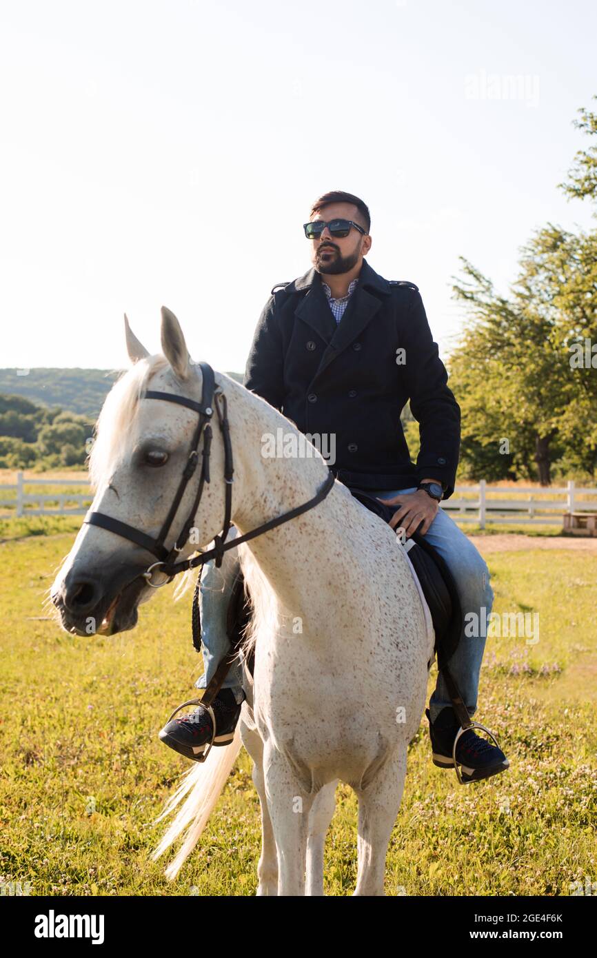 The young man is riding a horse on a farm Stock Photo - Alamy
