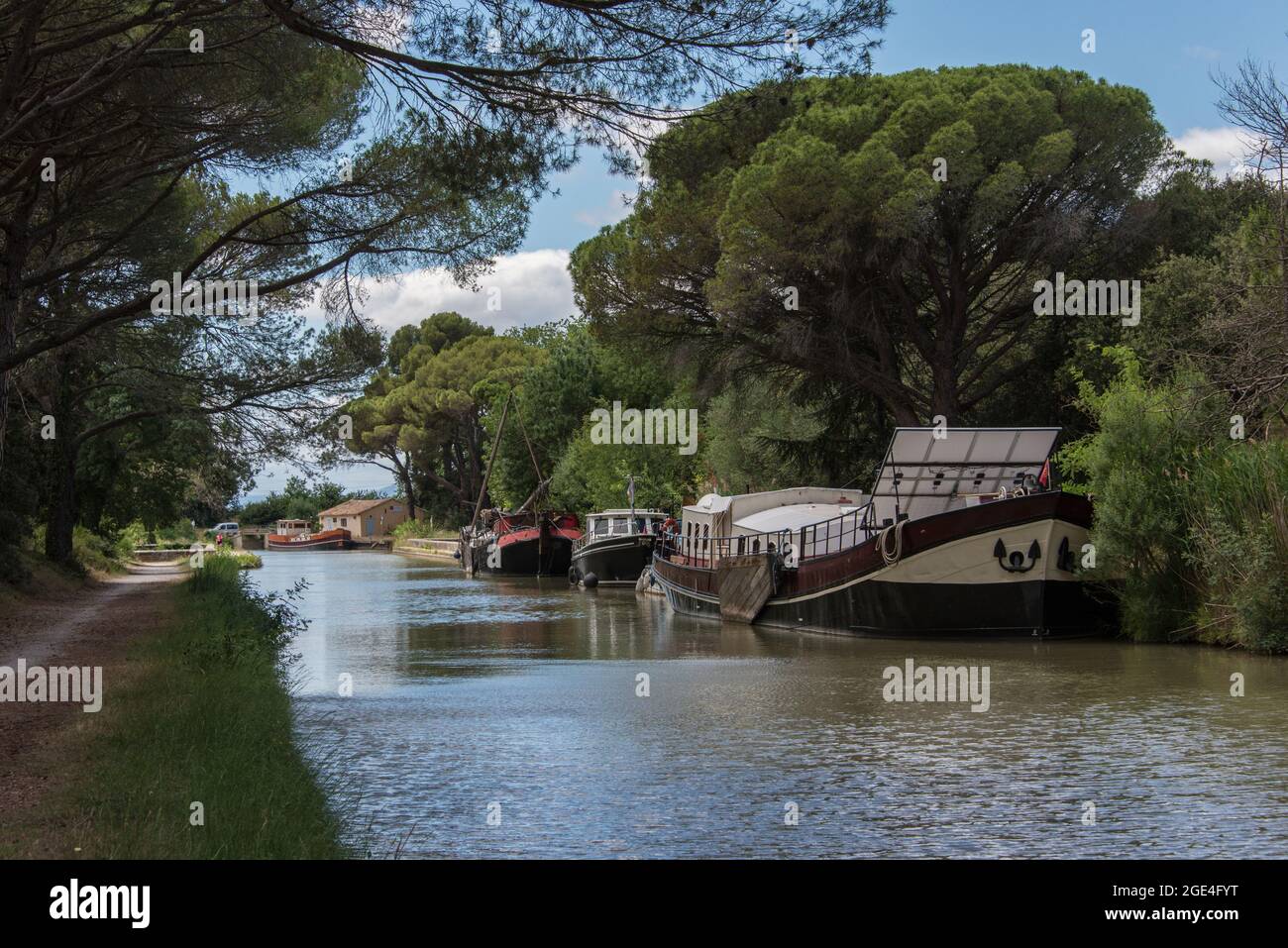 Former river barges transformed into houseboats lying along the Canal du Midi Stock Photo