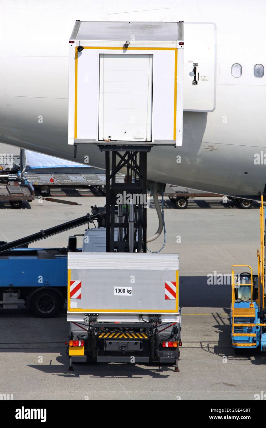 catering truck serving aircraft at international airport Stock Photo