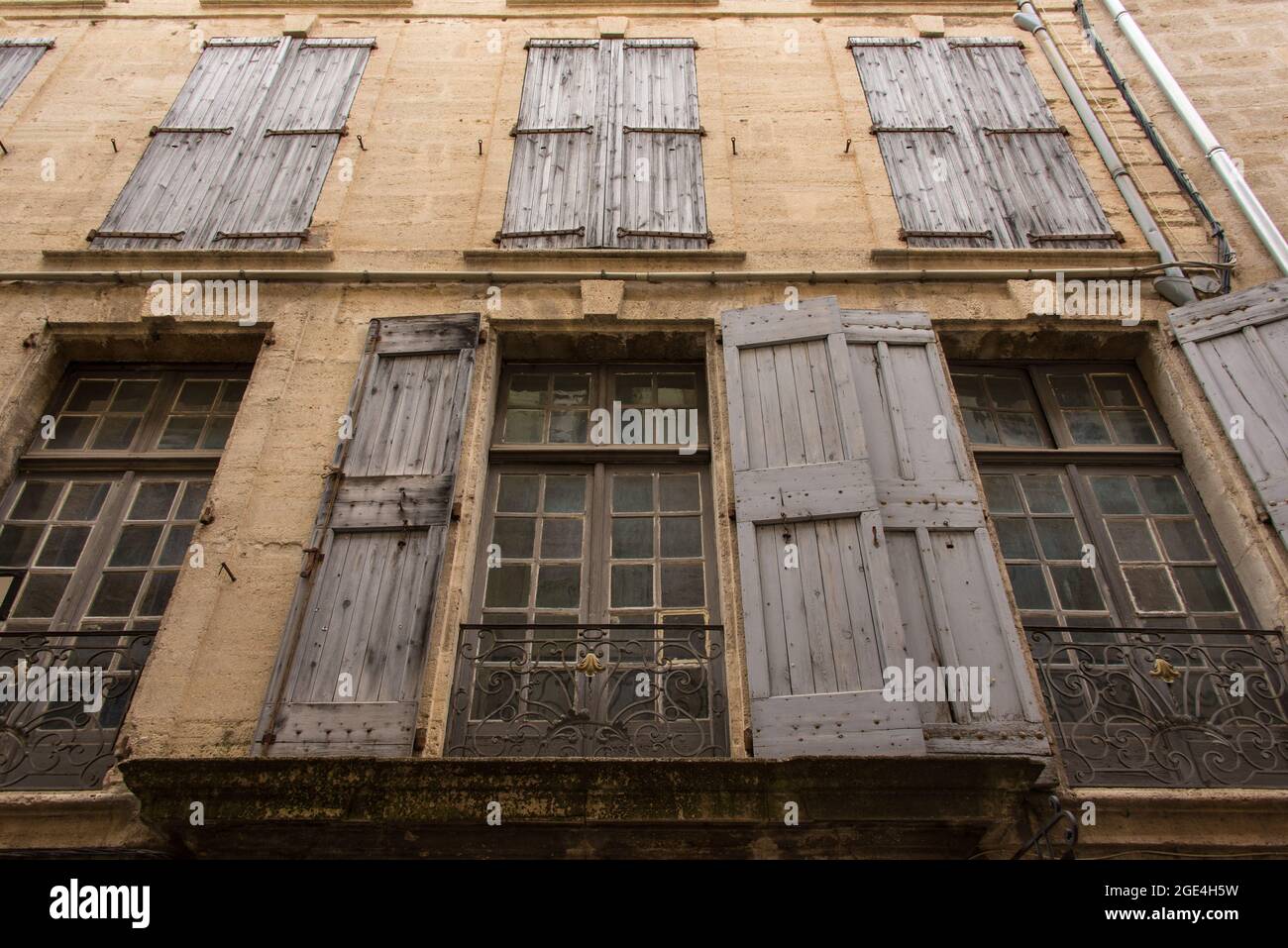 Die Patina der Vergangenheit: Eine Fensterfront in der Altstadt von Pézenas - the patina of history. A facade in the historic city centre of Pézenas. Stock Photo