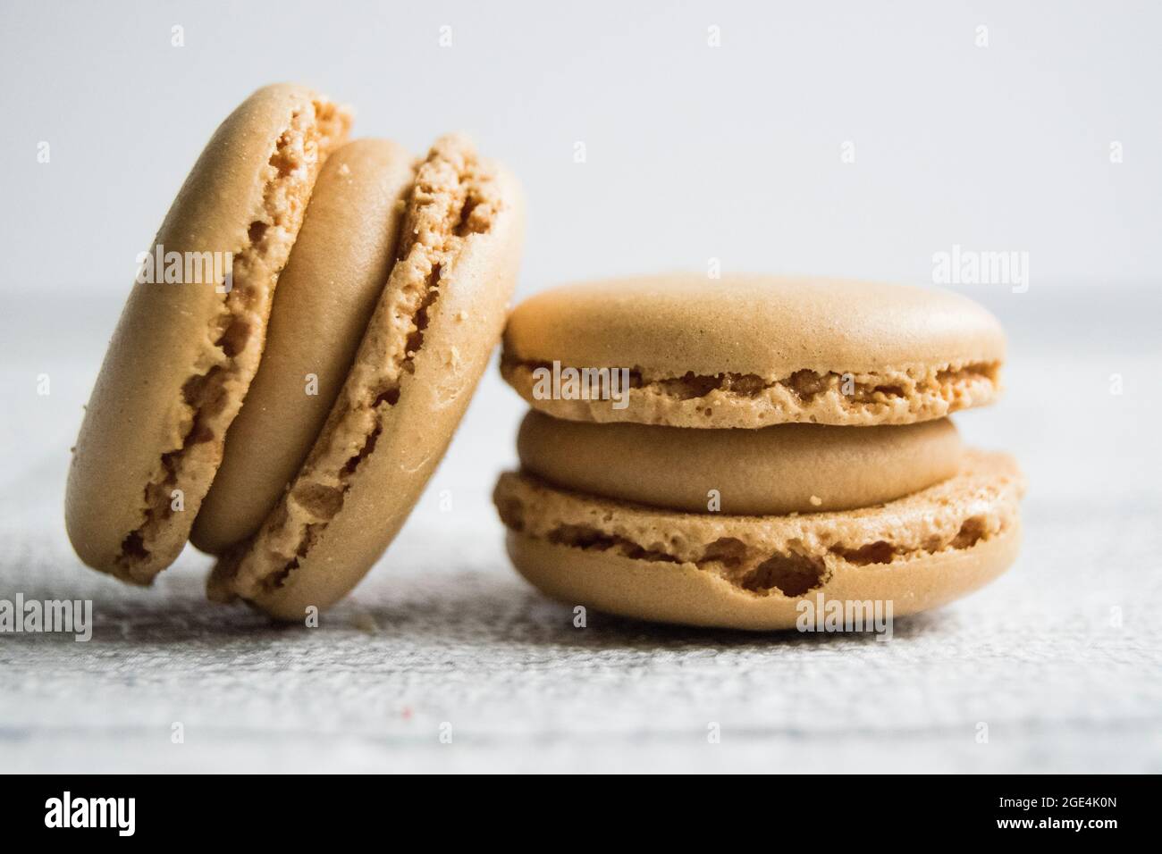 Small selection of macarons on a white washed wooden table top Stock Photo