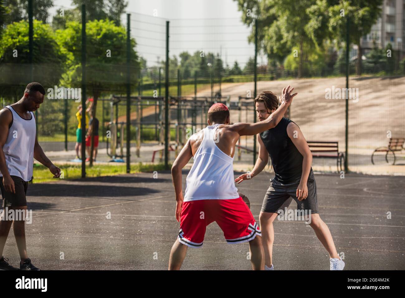 Man playing basketball with african american friends on outdoor playground  Stock Photo - Alamy
