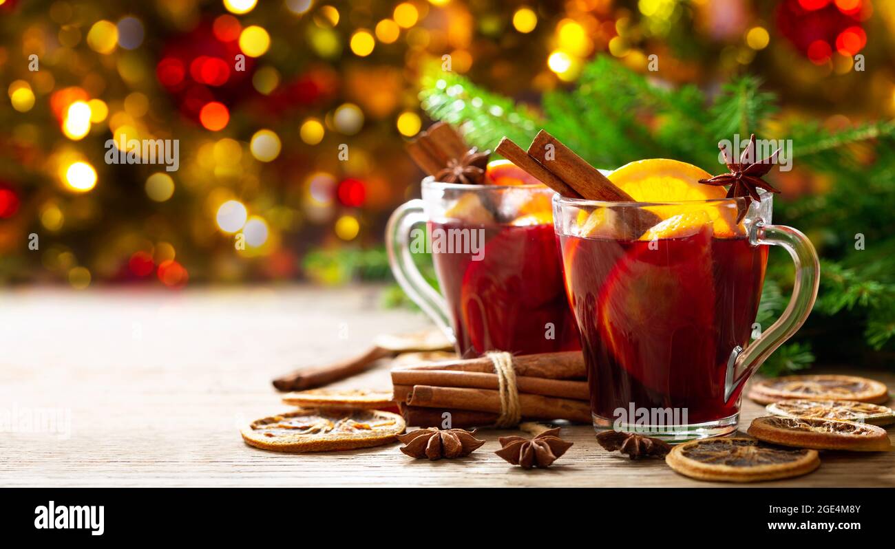 Christmas drink. Glasses of hot mulled wine with oranges, anise and cinnamon on festive background Stock Photo