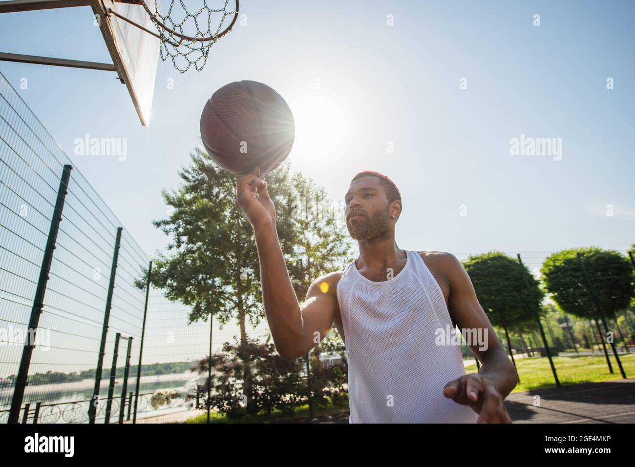 Young african american man holding basketball ball outdoors at daytime Stock Photo