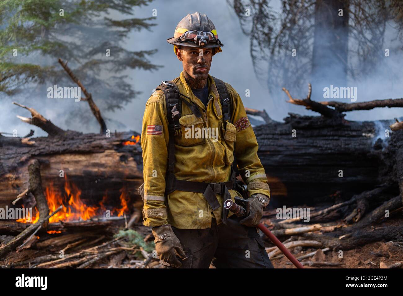 Chester, Ca, USA. 13th Aug, 2021. Firefighter Grant Kemp, 33, poses for a portrait after hosing down the large tree in the background and battling the Dixie Fire near Chester, CA on August 13, 2021. Kemp is a former contestant on The Bachelorette. (Photo by Daniel Brown/Sipa USA) Credit: Sipa USA/Alamy Live News Stock Photo