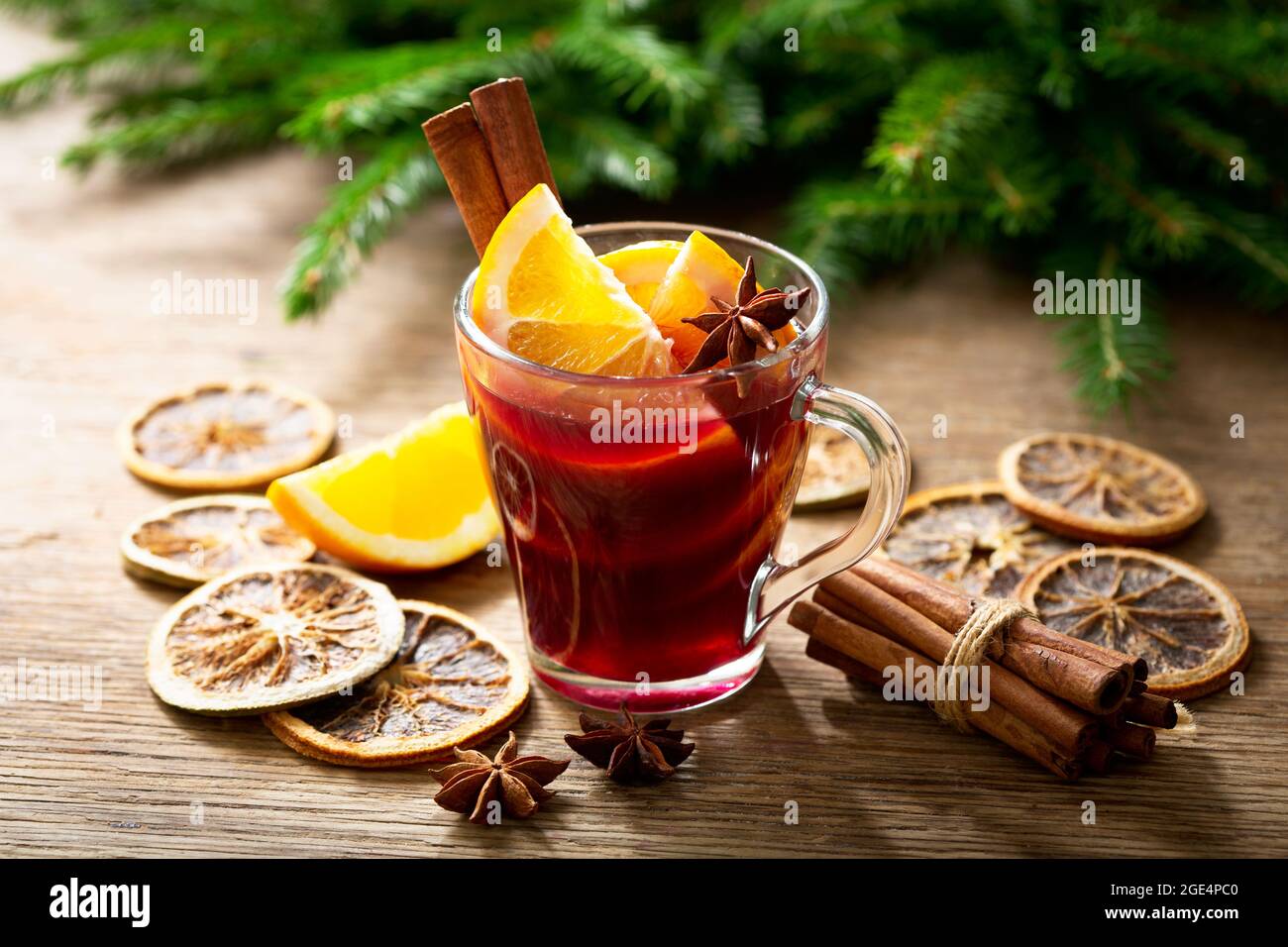Christmas drink. Glass of hot mulled wine with oranges, anise and cinnamon on festive background Stock Photo