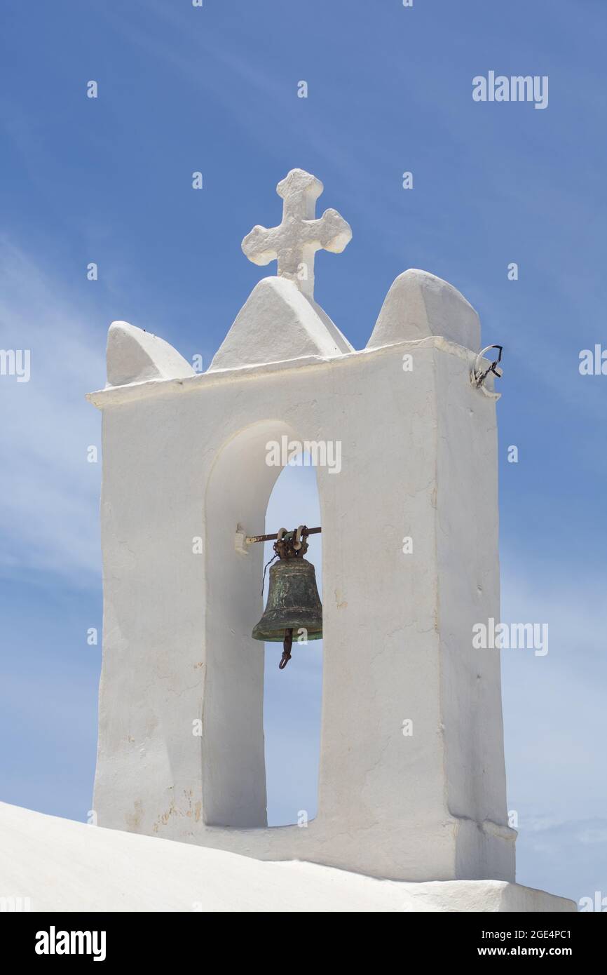 Ios island, Greece. Beautiful traditional Greek church.. Low angle shot of bell tower of a small chapel.  Vertical shot with clear blue sky and copy s Stock Photo