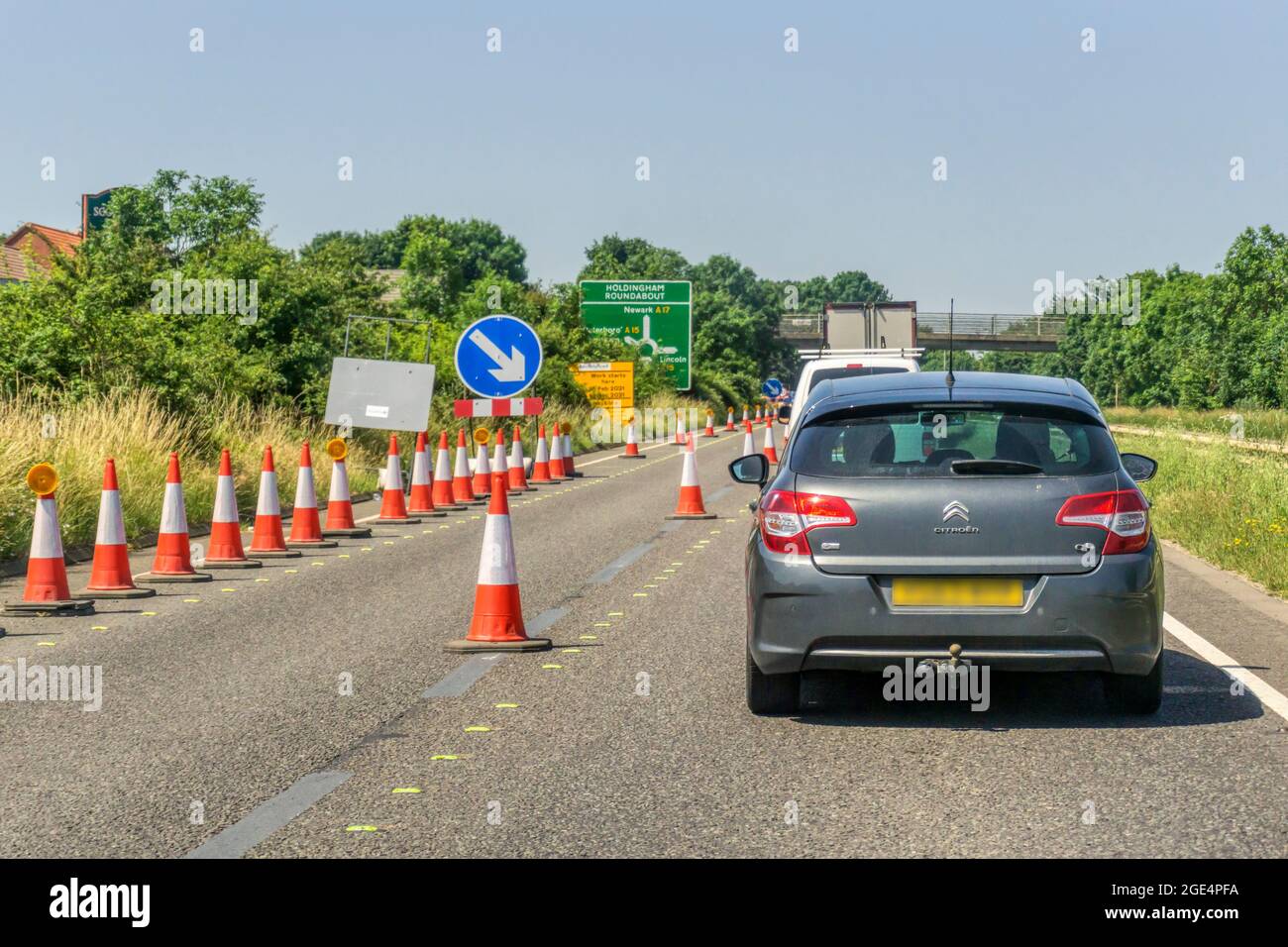 Cars queueing through a coned off section of roadworks on dual carriageway A17 road outside Sleaford in Lincolnshire. Traffic heading west. Stock Photo