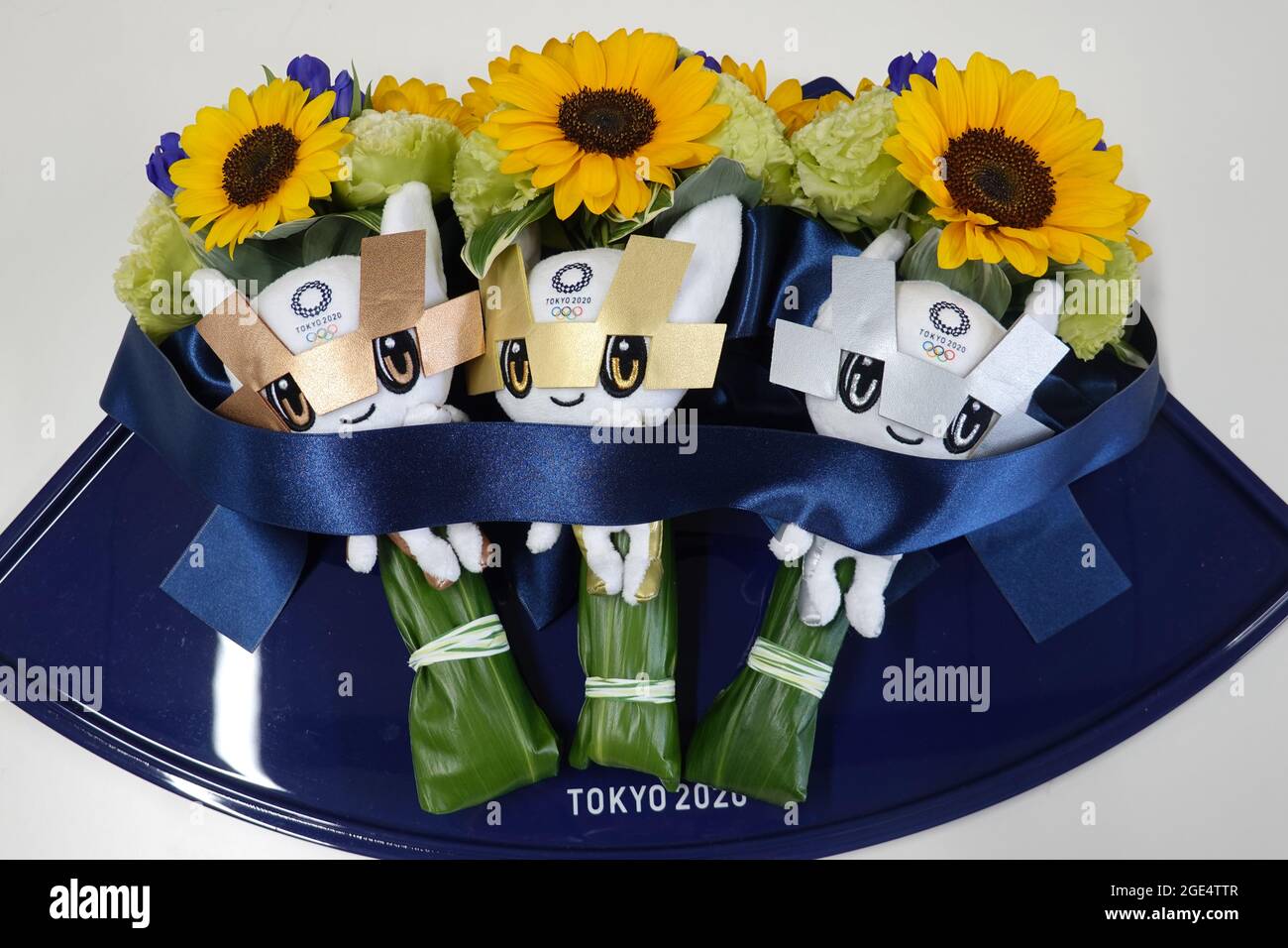 Tokyo 2020 Olympic podium flowers and gold, silver and bronze Miraitowa mascots on a tray before a medal presentation Stock Photo