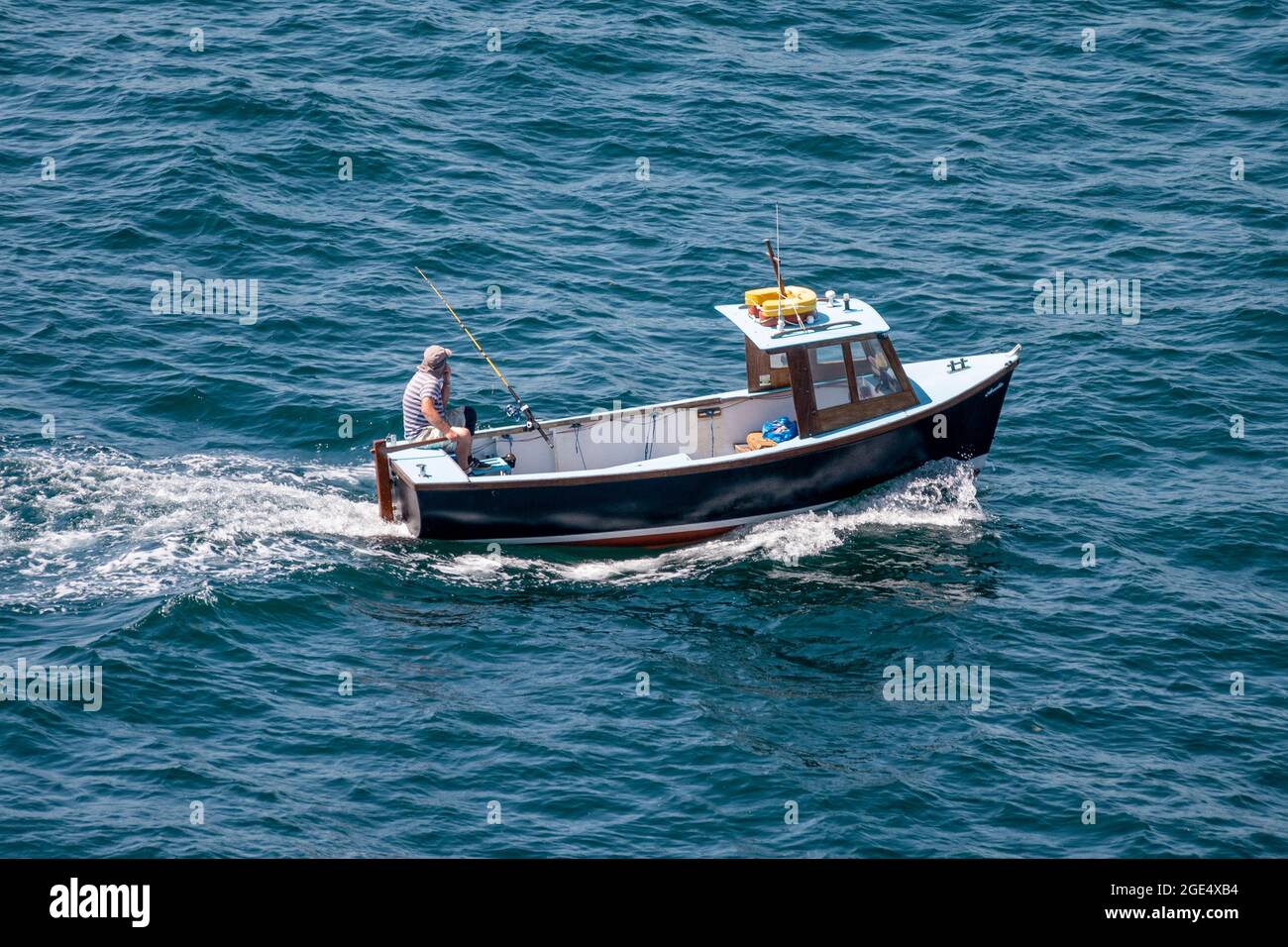 A rod and line fisherman pictured off Polruan, Cornwall, UK. Stock Photo
