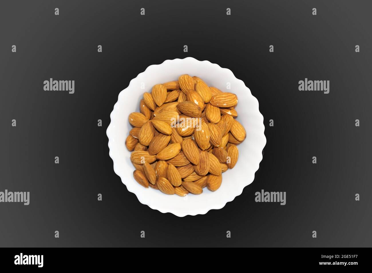 Closeup Image Of Almond Inside White Bowl. Grey Background Stock Photo