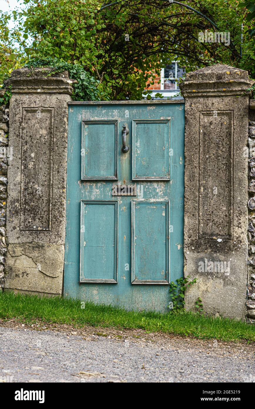 a blue painted aged wooden door leading to the garden of the Manor House Stock Photo