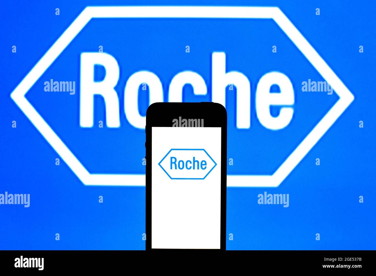 In this photo illustration, a Hoffmann–La Roche AG logo seen displayed on a smartphone and in the background. Stock Photo