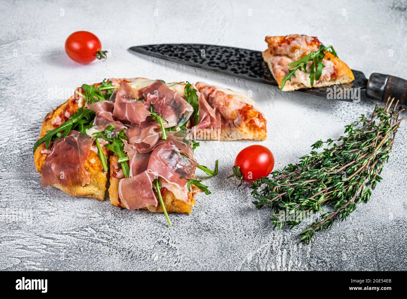 Italian Pizza with parma ham, arugula and cheeseon a kitchen table