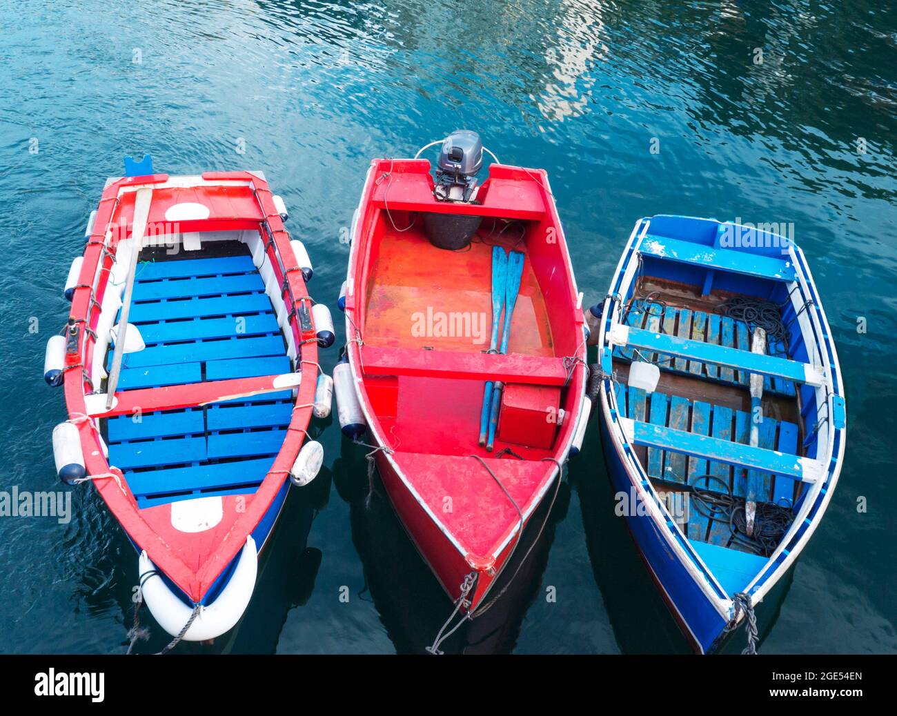 LUARCA, SPAIN - DECEMBER 4, 2016: Three bright painted boats at the fish market pier in Luarca, Spain. Stock Photo