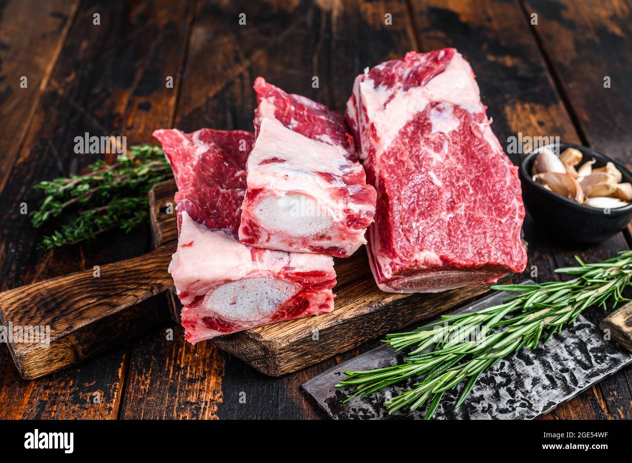 Raw beef calf short ribs meat on a butcher cutting board with cleaver ...