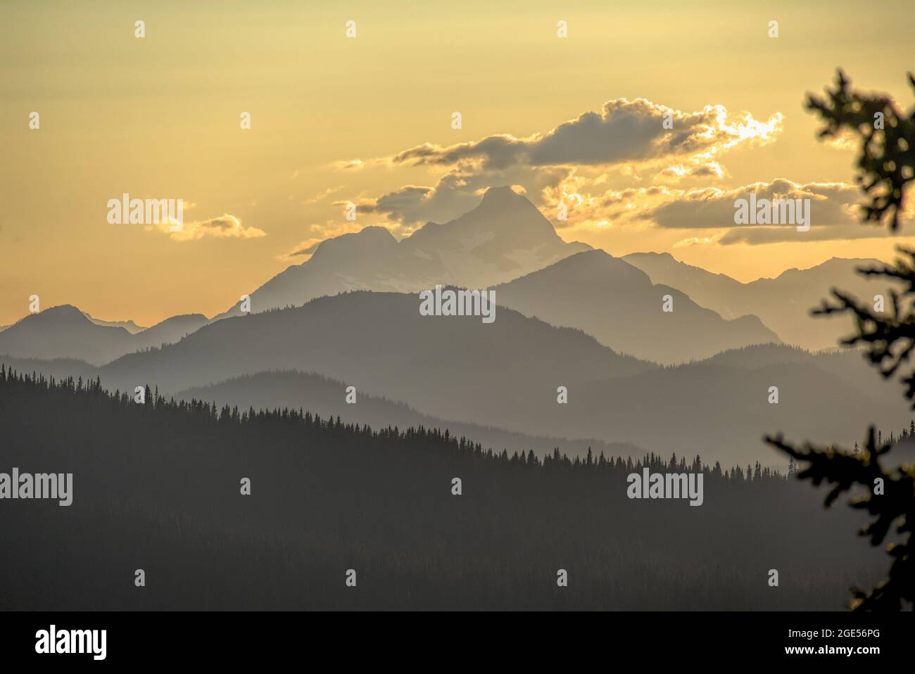 Golden skies at sunset and receeding forested ridges looking toward Washington State's Mount Hozomeen from Manning Park, BC, Canada Stock Photo