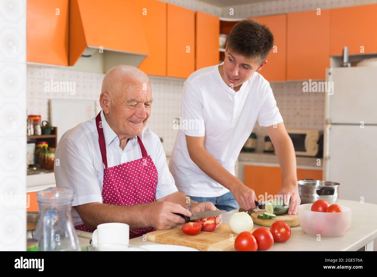 Teenage boy cooking with grandfather Stock Photo - Alamy