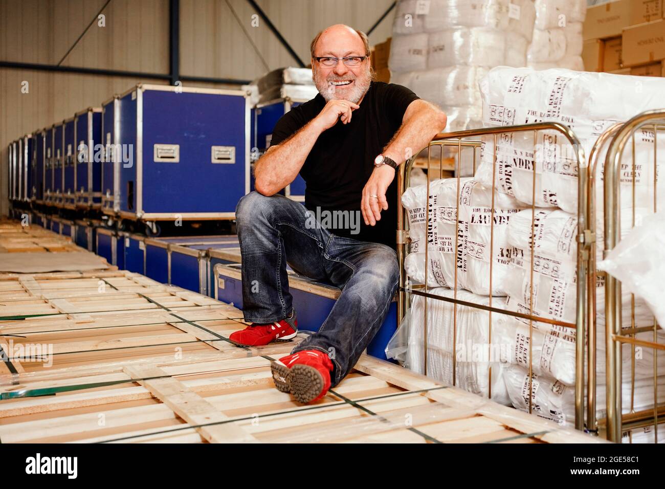 Speyer, Germany. 23rd June, 2021. Hans-Jürgen Topf, owner of the company  "Rock'n'Roll Laundry", sits in a warehouse between washing machines and  towels packed in Rodie cases. The German has been washing stars'