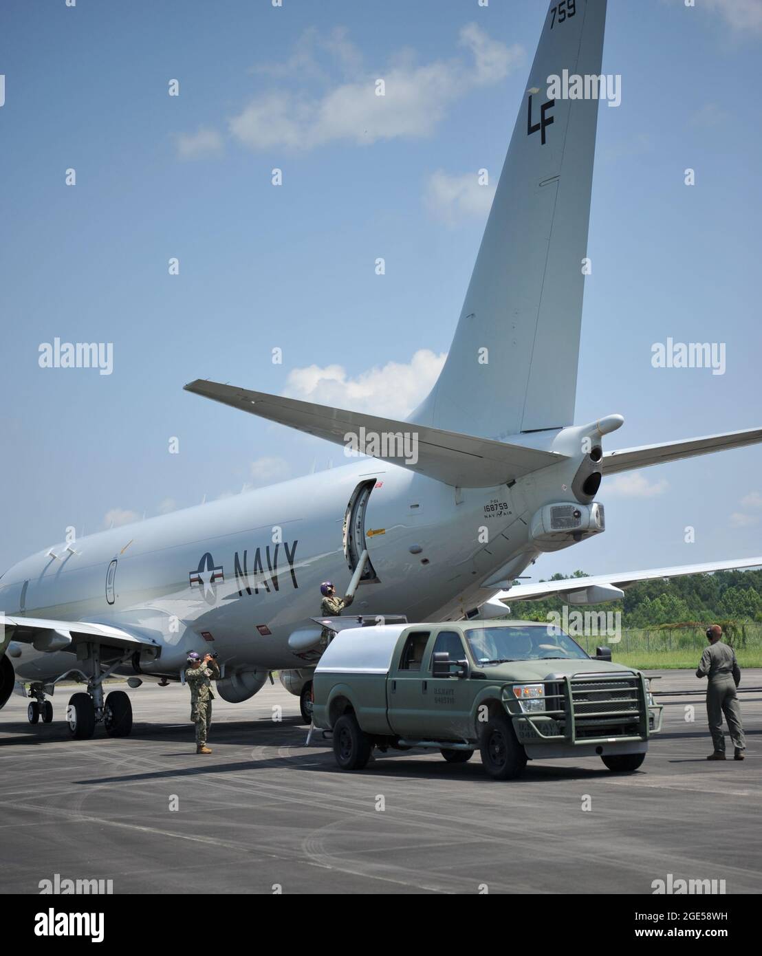 Sailors from Navy Cargo Handling Battalion ONE transfer sonobuoys to a Navy P-8 Poseidon, from Patrol and Reconnaissance Squadron (VP) 16 at a forward arming and refueling point (FARP) operated by Marines from Marine Wing Support Squadron 271 Aviation Mobility Company, FARP Platoon, demonstrating the integration of force capabilities at Kinston, N.C. as part of Large-Scale Exercise (LSE 2021), Aug. 12, 2021. LSE 2021 demonstrates the Navy’s ability to employ precise, lethal, and overwhelming force globally across three naval component commands, five numbered fleets, and 17 time zones. LSE 2021 Stock Photo