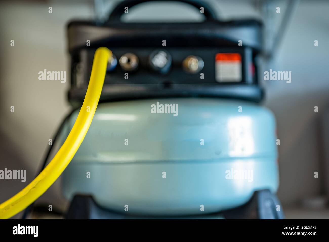 Selective focus on a hose connected to a Pancake air compressor sitting