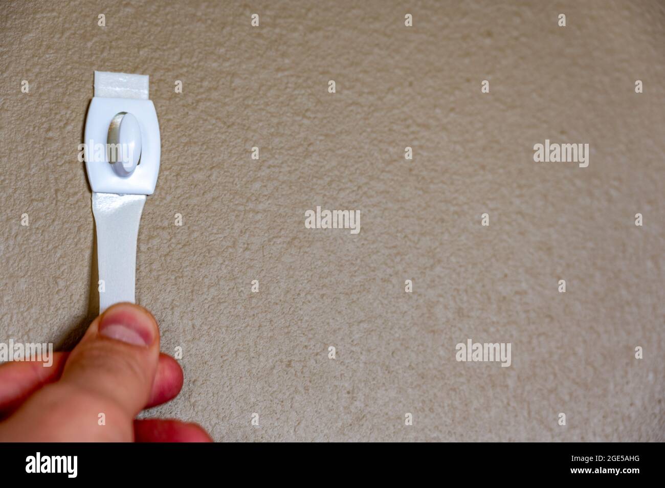 Selective focus on adhesive strip wall hanger that can be removed by