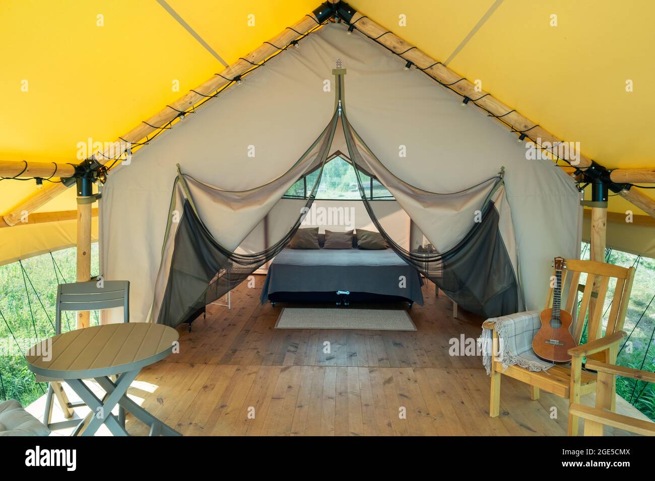 Interior of luxurious family glamping house with bed, table and chairs Stock Photo